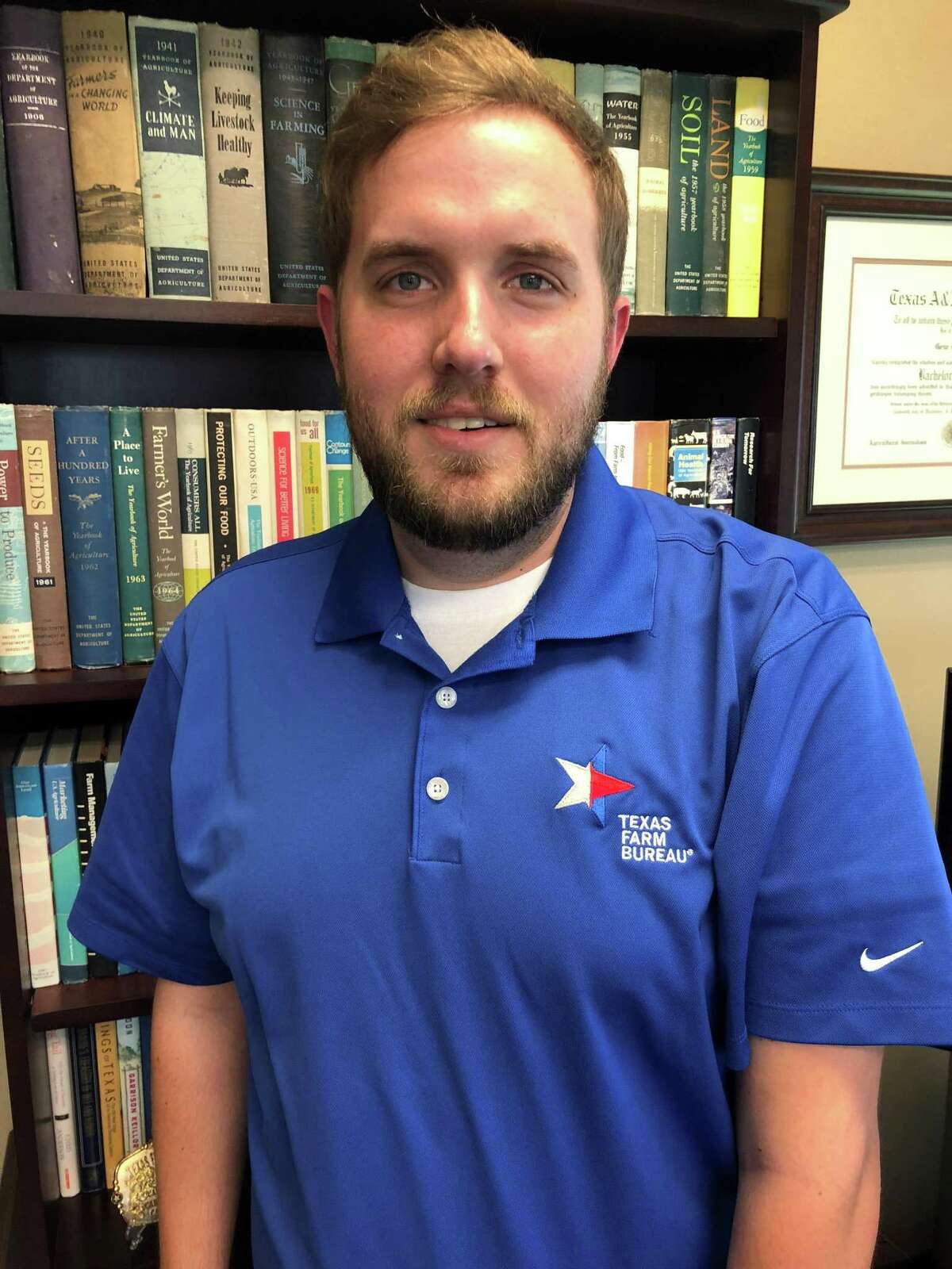 Justin Walker, a member of the communications staff at the Texas Farm Bureau, in a TFB shirt co-branded with the Nike logo. The Texas Farm Bureau, wanting to avoid appearing to take a political stance, has asked personnel not to wear the Nike-logoed shirts