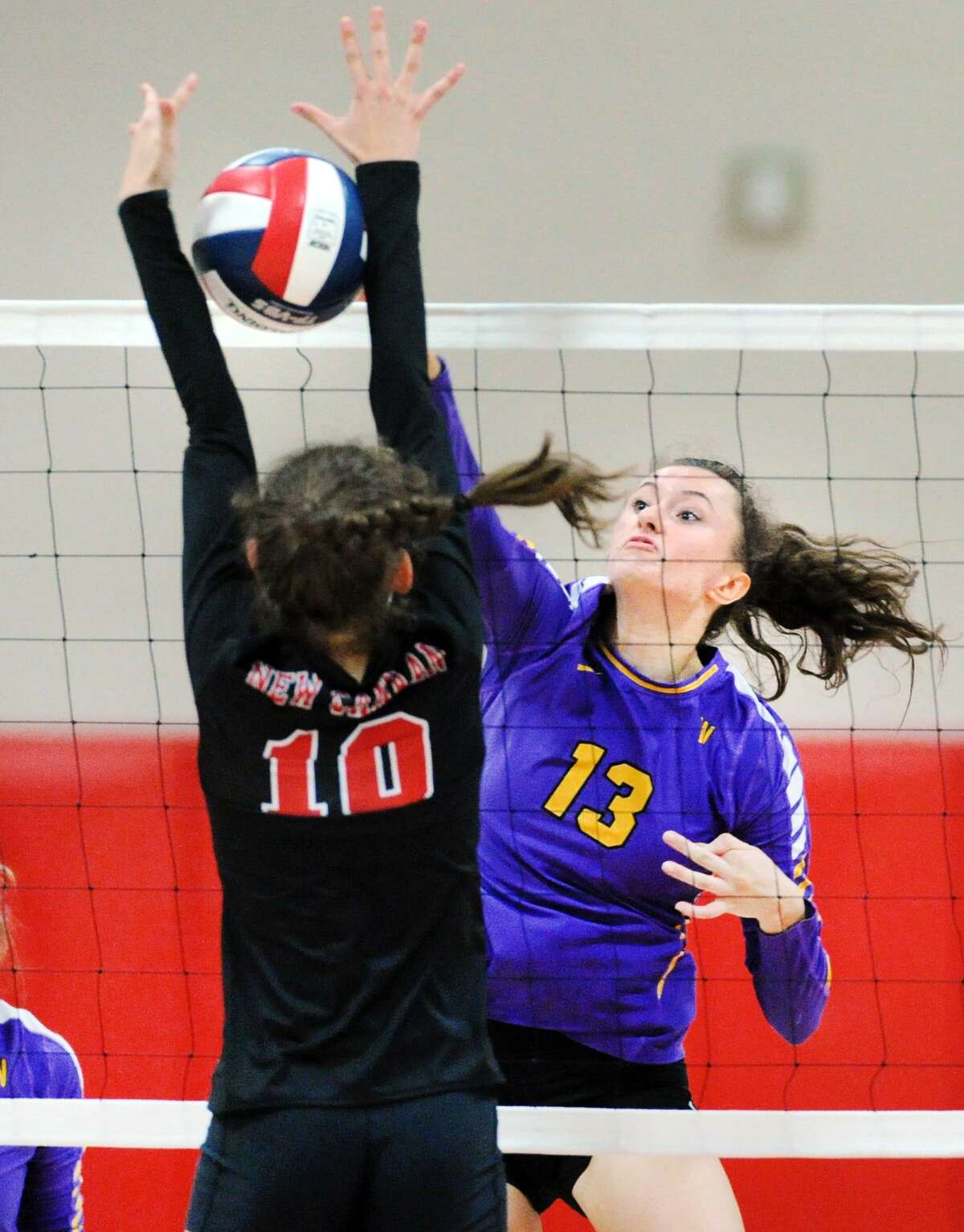 Westhill’s Betsy Sachs of Westhill (13) drives a spike past New Canaan’s Alexandra Gillespie during Tuesday’s contest.