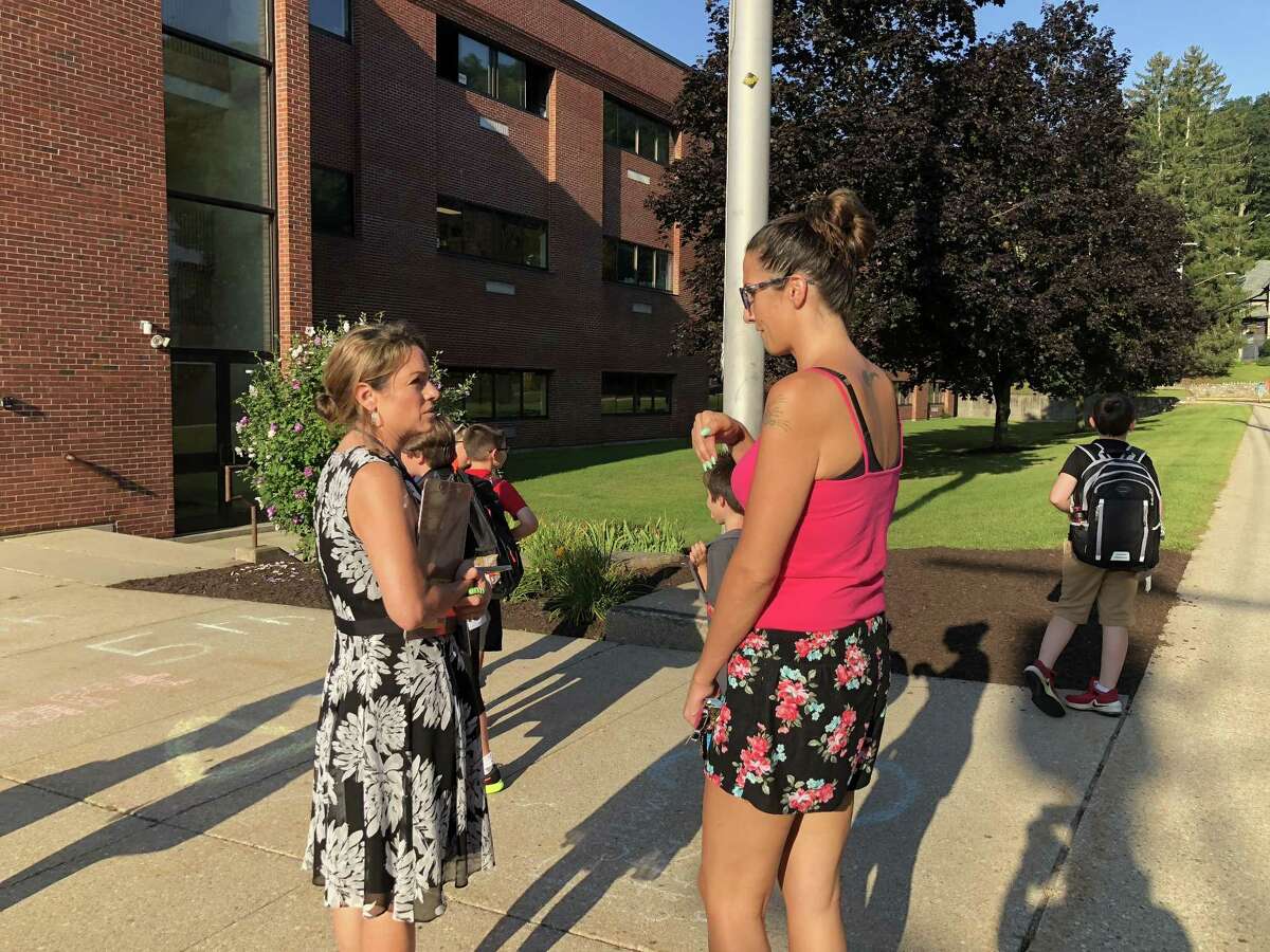 Above, Isabelle M. Pearson School Principal Barbara Silverio with a parent on the first day of school.