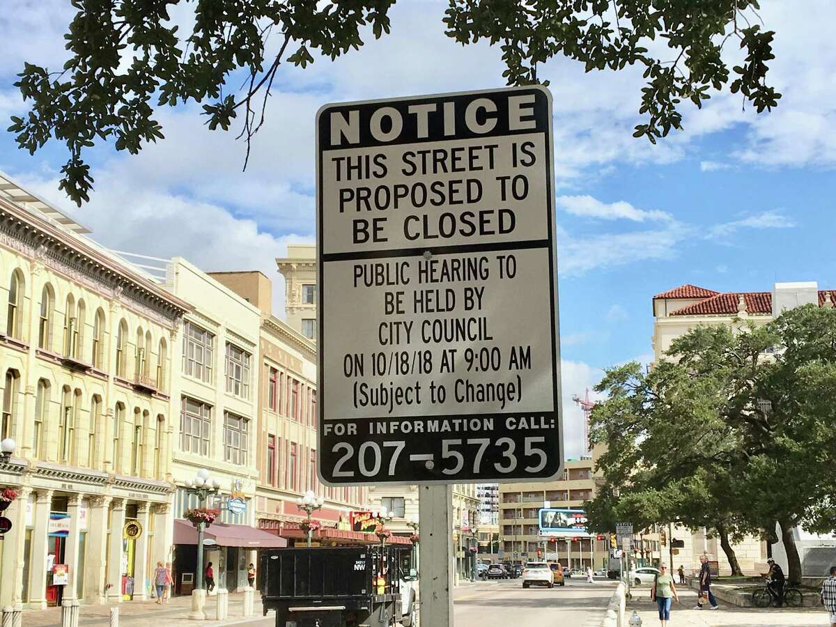 A sign posted on Alamo Street notifies the public of the upcoming hearing about the closure of the street to traffic.
