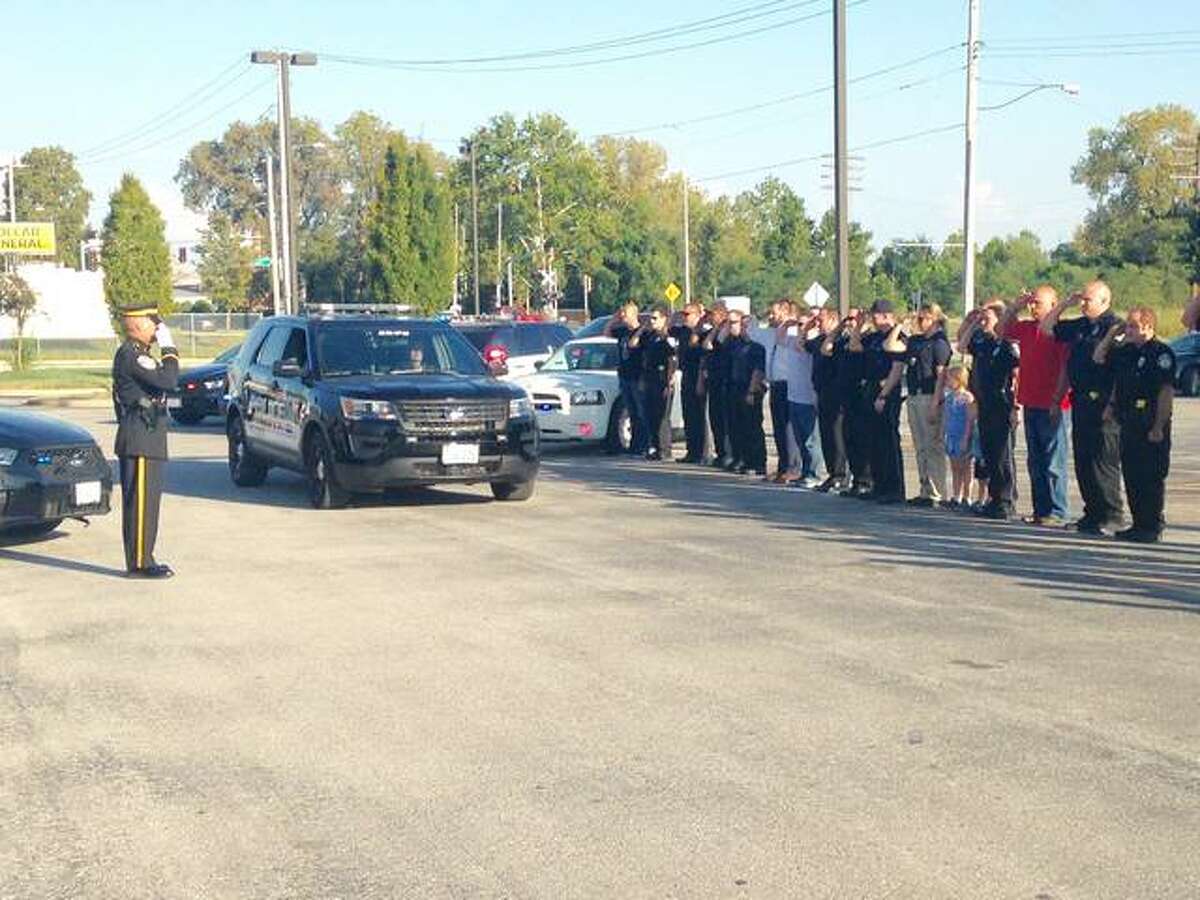 Current and retired Alton police officers salute retiring, Pfc. David Penney as he takes his final drive in a patrol car at the Donald E. Sandidge Alton Law Enforcement Center.