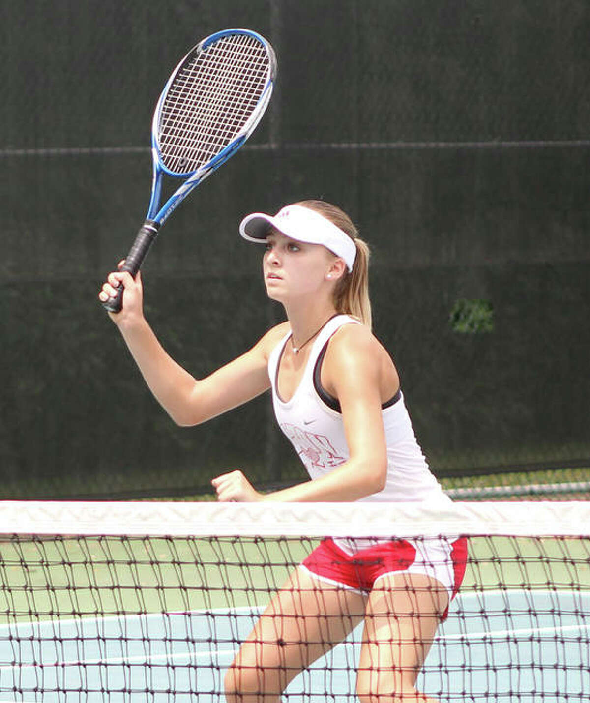 Alton’s Ainsley Fortschneider, shown getting ready for a return at the net in a double match earlier this season, won singles and doubles matches Tuesday in a Redbirds’ win over St. Charles (Mo.) Duchesne.