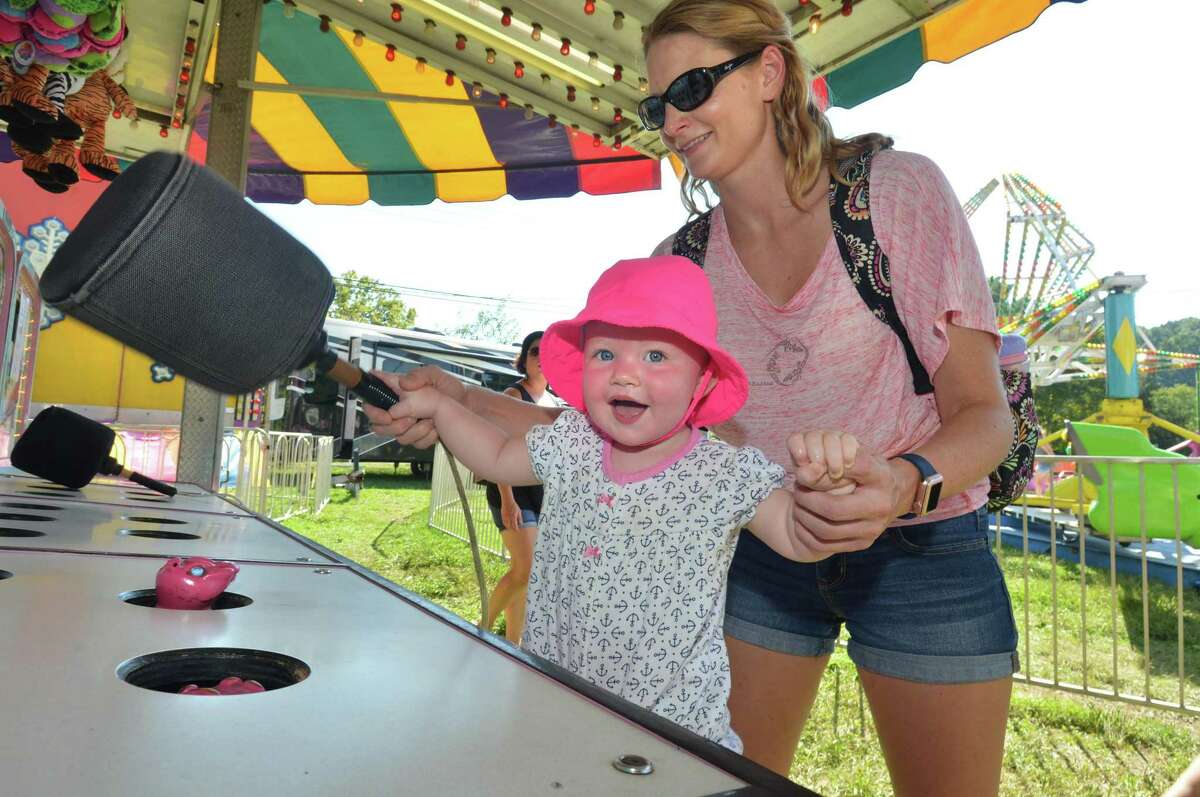 Sara Froehlich gets help from her mom Lexi as she plays Whac-A-Mole during the Wilton Rotary Club annual family carnival on Sunday September 16, 2018 in Wilton Conn. The event is a fundraiser that benefits the Wilton Rotary Club's community improvement projects both locally and internationally.