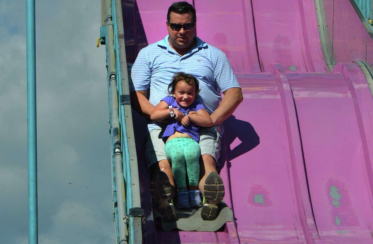 Josh Cole holds onto his daughter Giovanna as they come down the giant slide at the Wilton Rotary Club annual family carnival on Sunday September 16, 2018 in Wilton Conn. The event is a fundraiser that benefits the Wilton Rotary Club's community improvement projects both locally and internationally.
