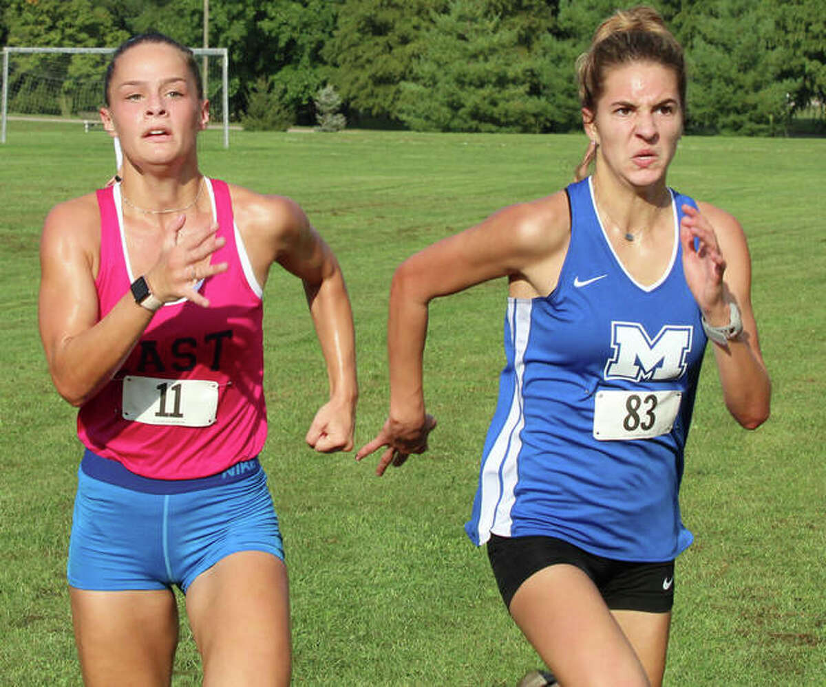 Belleville East’s Hannah Eastman (left) and Marquette Catholic’s Riley Vickrey sprint the final yards to the finish Wednesday at the Alton Invitational cross country meet at Moore Park in Alton. No results were released and entire field was disqualified after a wrong turn left all the girls about a mile short on the three-mile layout.
