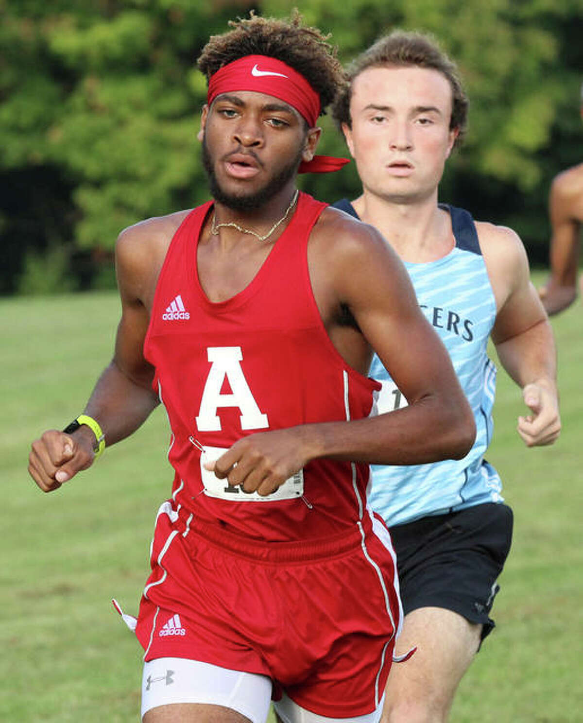 Alton’s Cassius Havis (front) leads the pack in the first mile with Belleville East’s Zach Panek right behind Wednesday at the Alton Invite at Moore Park. Panek finished fifth and Havis was sixth in the race.