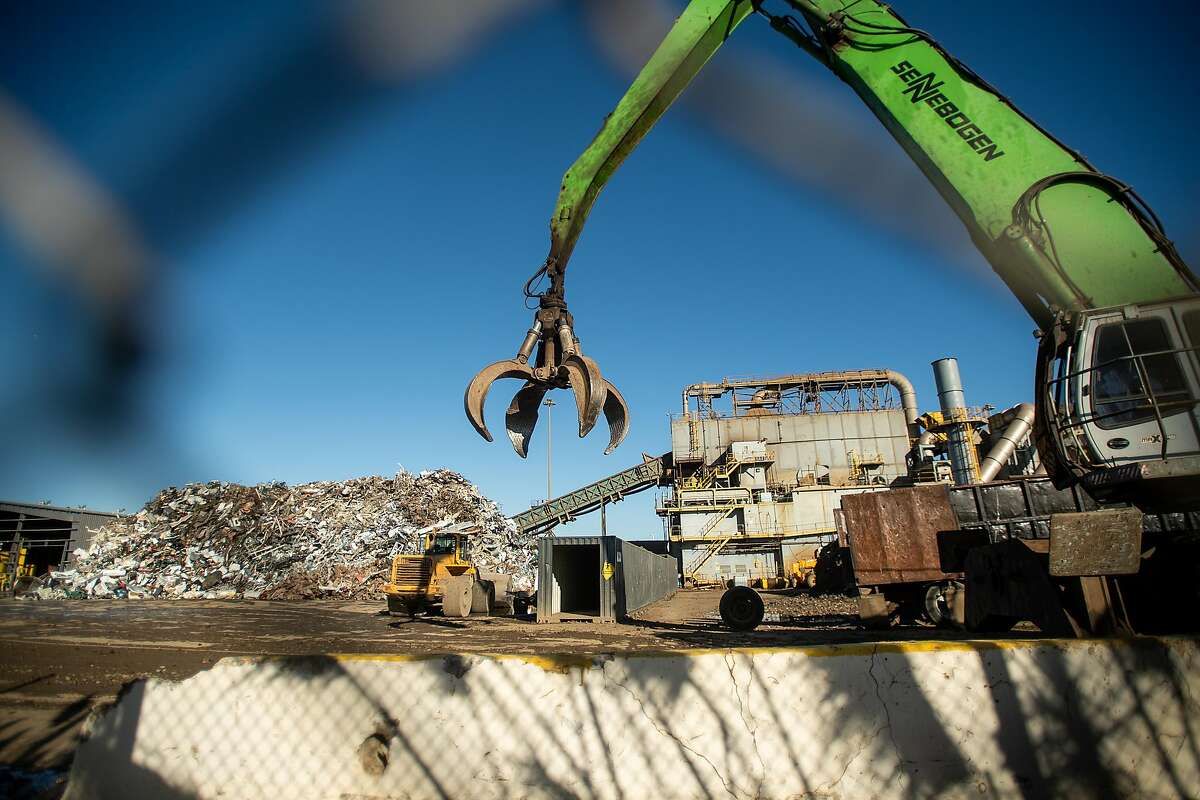 A crane with a grab claw traverses Schnitzer Steel's recycling yard on Monday, Sept. 17, 2018, in Oakland, Calif. The facility sits adjacent to a proposed location for a new Oakland Athletics ballpark.