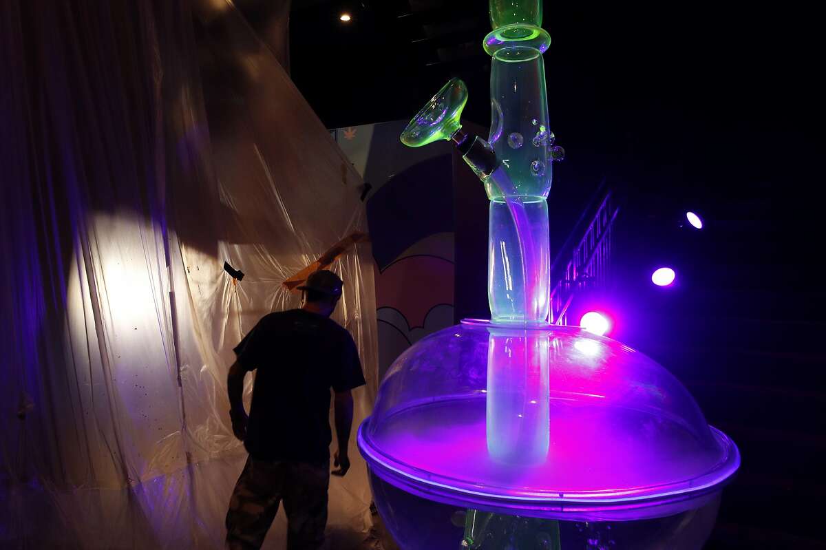 In this Tuesday, Sept. 18, 2018 photo, a man walks by a 24-foot-tall bong at the Cannabition cannabis museum in Las Vegas. The museum celebrating all things cannabis with displays that include a glass bong taller than a giraffe and huggable faux marijuana buds is the newest tourist attraction in Las Vegas.