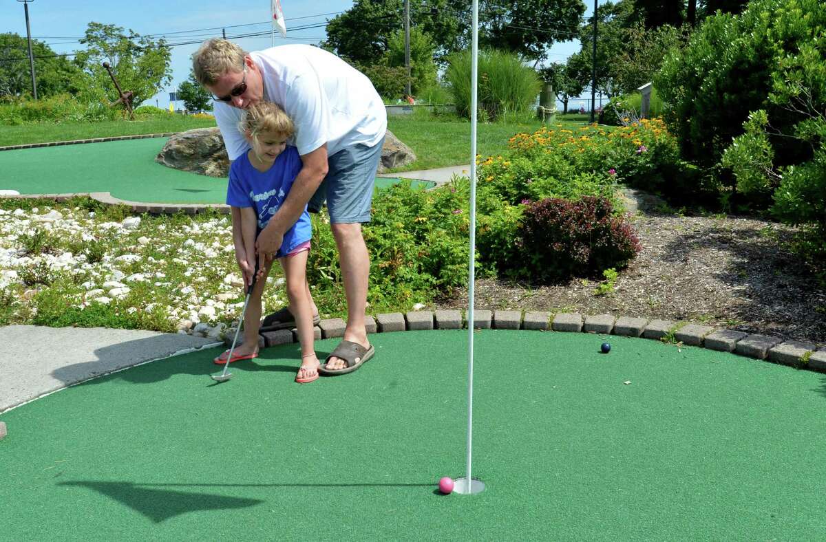 Patrick Caciolo and daughter Emily play a game of mini golf at Norwalk Cove Marina Mini Golf on a recent sunny afternoon