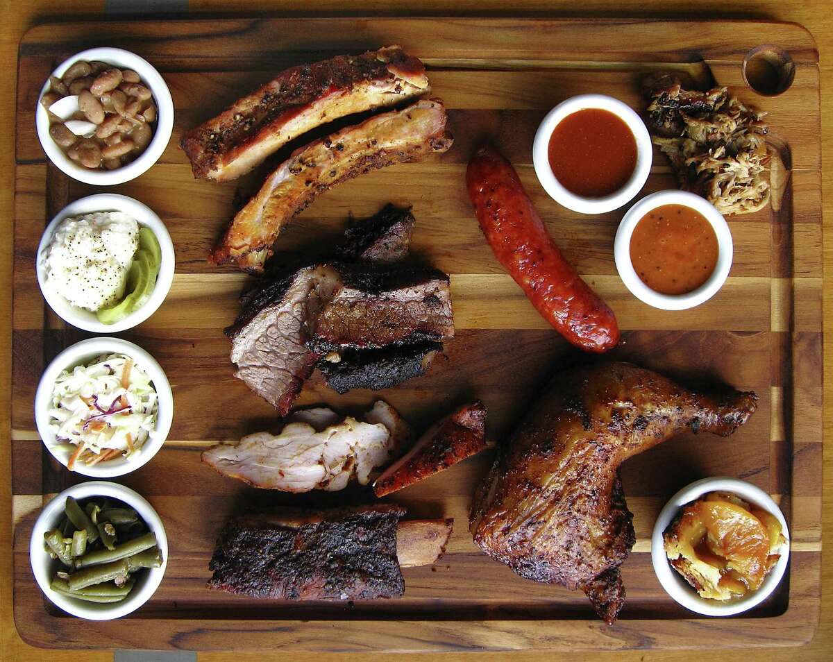 Barbecue and sides from The Barbecue Station. Clockwise from top left: pinto beans, pork ribs, sausage, regular barbecue sauce, pulled pork, mustard barbecue sauce, chicken, peach cobbler, center-cut beef back ribs, green beans, cole slaw, potato salad, brisket and turkey.