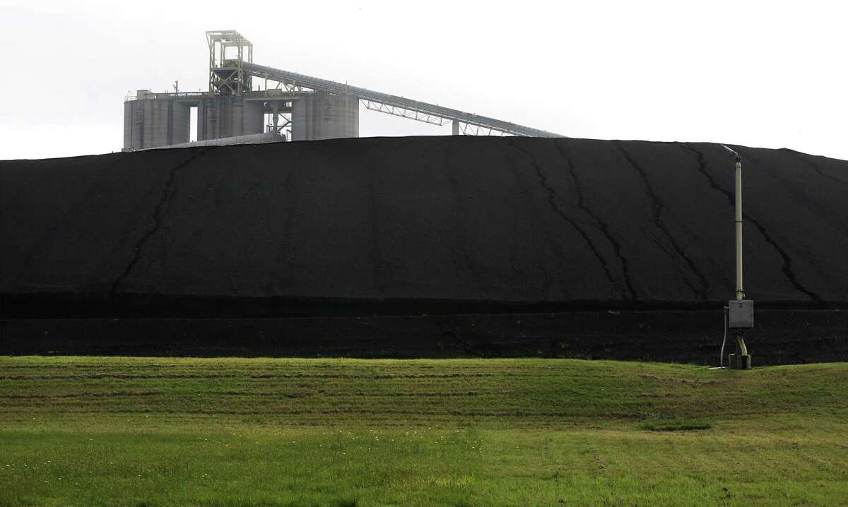 A conveyor belt is seen rising above a pile of coal that is burned at the adjacent J.T. Deely and J.K. Spruce power plants. Deely is being shut down by city-owned utility CPS Energy at the end of the year.