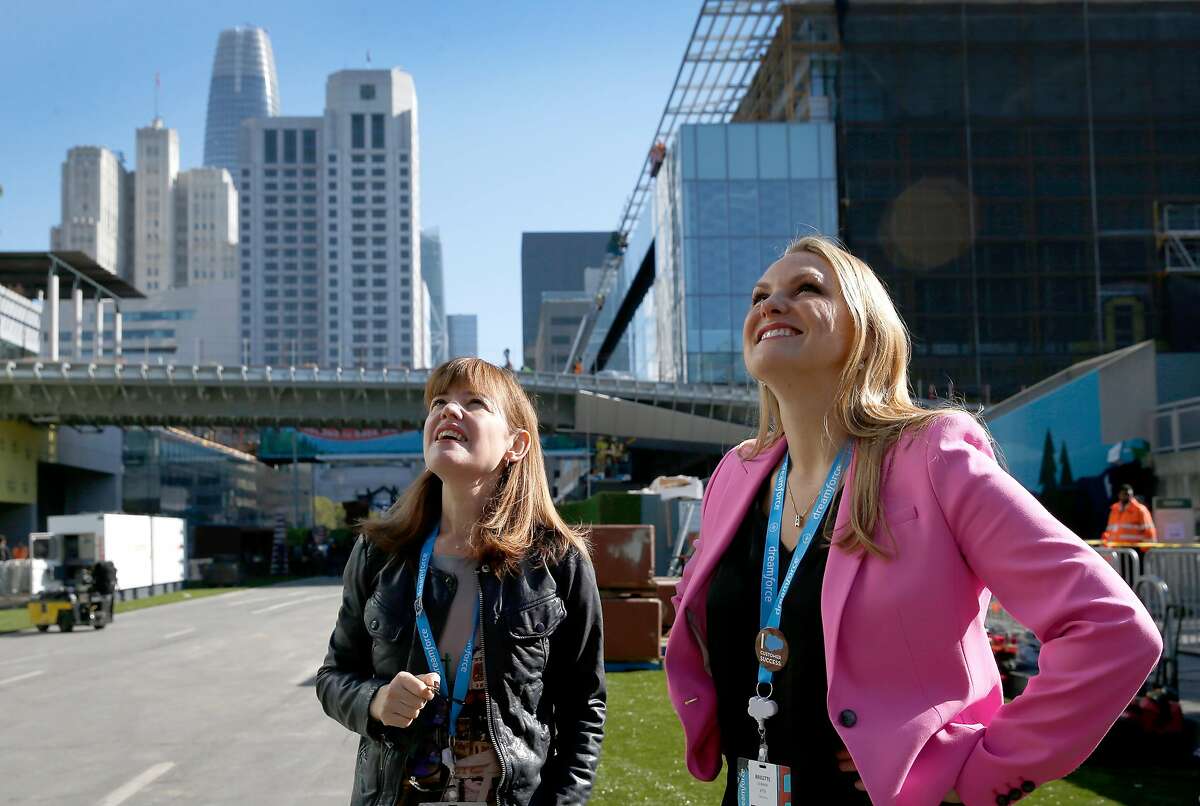 Dreamforce conference organizers Catherine Simmons (left) and Brigitte Donner view the giant artificial tree trunk on Howard Street that will greet attendees at Moscone Center in San Francisco, Calif. on Friday, Sept. 21, 2018. The annual conference hosted by Salesforce featuring a national park theme is expected to draw as many as 170,000 attendees.