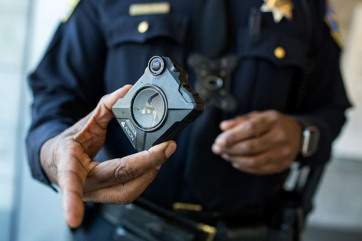 Joseph Tomlinson, public information officer, demonstrates a body camera that police officers use when on duty. Each camera has an officer's name on it and it's picked up before shift and dropped off afterwards to charge. At San Francisco Police Department on Friday, September 21, 2018 in San Francisco Calif.