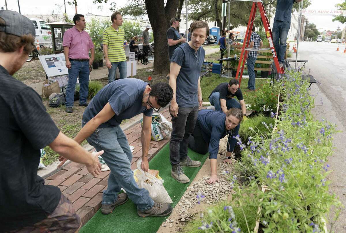 San Antonio River Authority employees prepare a small park with permeable pavement, bioretention features and native plants on Friday along McCullough Avenue. Their work was part of the national PARK(ing) Day event, which transforms concrete parking spaces into small parks in an effort to make urban spaces more inviting and walkable.