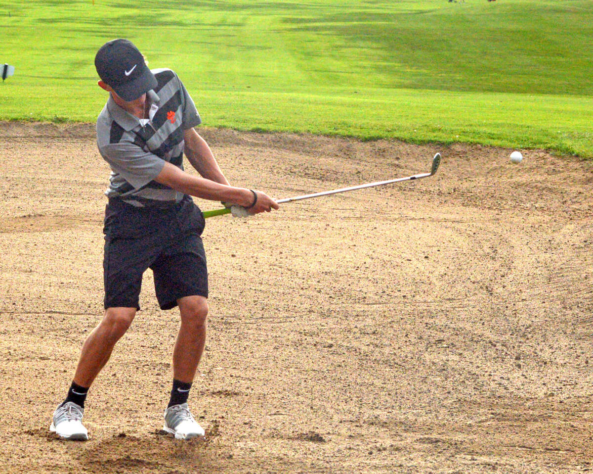 Edwardsville sophomore Hayden Moore hits out of a sand trap on Friday on hole No. 17 at Oak Brook Golf Club during the Dick Gerber Invitational.