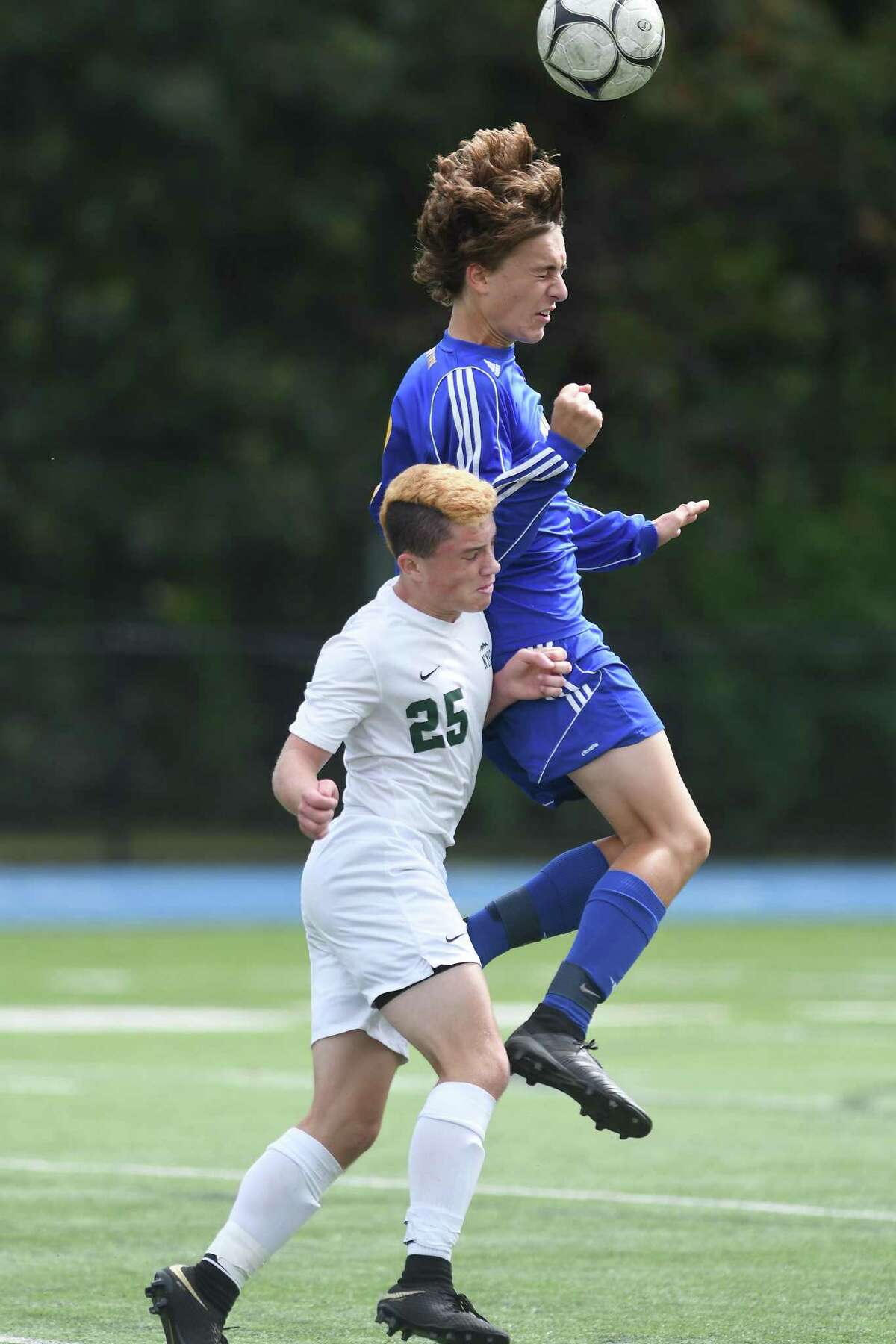 Newtown’s Ryan Rudy, top, heads the ball over New Milford’s Zachary Best during the New Milford at Newtown boys soccer game, Sept. 22, 2018.