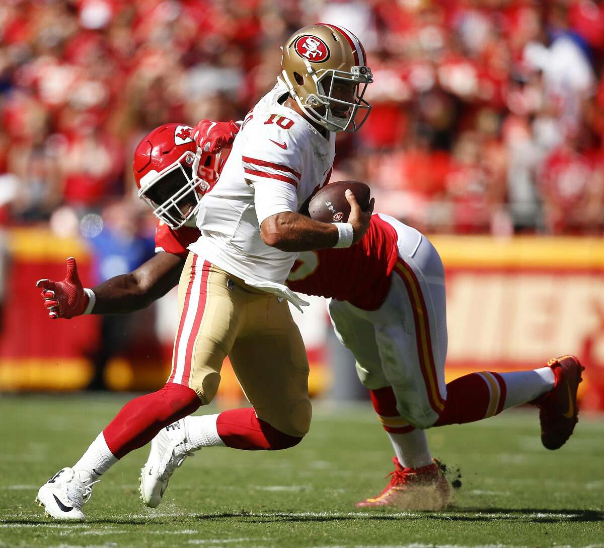KANSAS CITY, MO - SEPTEMBER 23: Jimmy Garoppolo #10 of the San Francisco 49ers escapes a sack attempt of Justin Houston #50 of the Kansas City Chiefs during the fourth quarter of the game at Arrowhead Stadium on September 23rd, 2018 in Kansas City, Missouri. (Photo by David Eulitt/Getty Images)