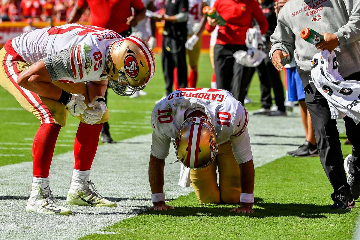 KANSAS CITY, MO - SEPTEMBER 23: George Kittle #85 of the San Francisco 49ers checks on injured teammate Jimmy Garoppolo #10 after a play in the fourth quarter of the game against the Kansas City Chiefs at Arrowhead Stadium on September 23rd, 2018 in Kansas City, Missouri. (Photo by Peter Aiken/Getty Images)