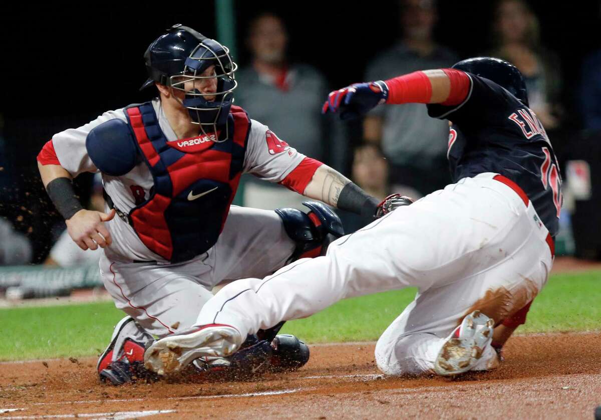Boston Red Sox catcher Christian Vazquez, left, tags out Cleveland Indians' Edwin Encarnacion at home plate on a fielder's choice hit into by Josh Donaldson in the second inning of a baseball game, Sunday, Sept. 23, 2018, in Cleveland. (AP Photo/Tom E. Puskar)