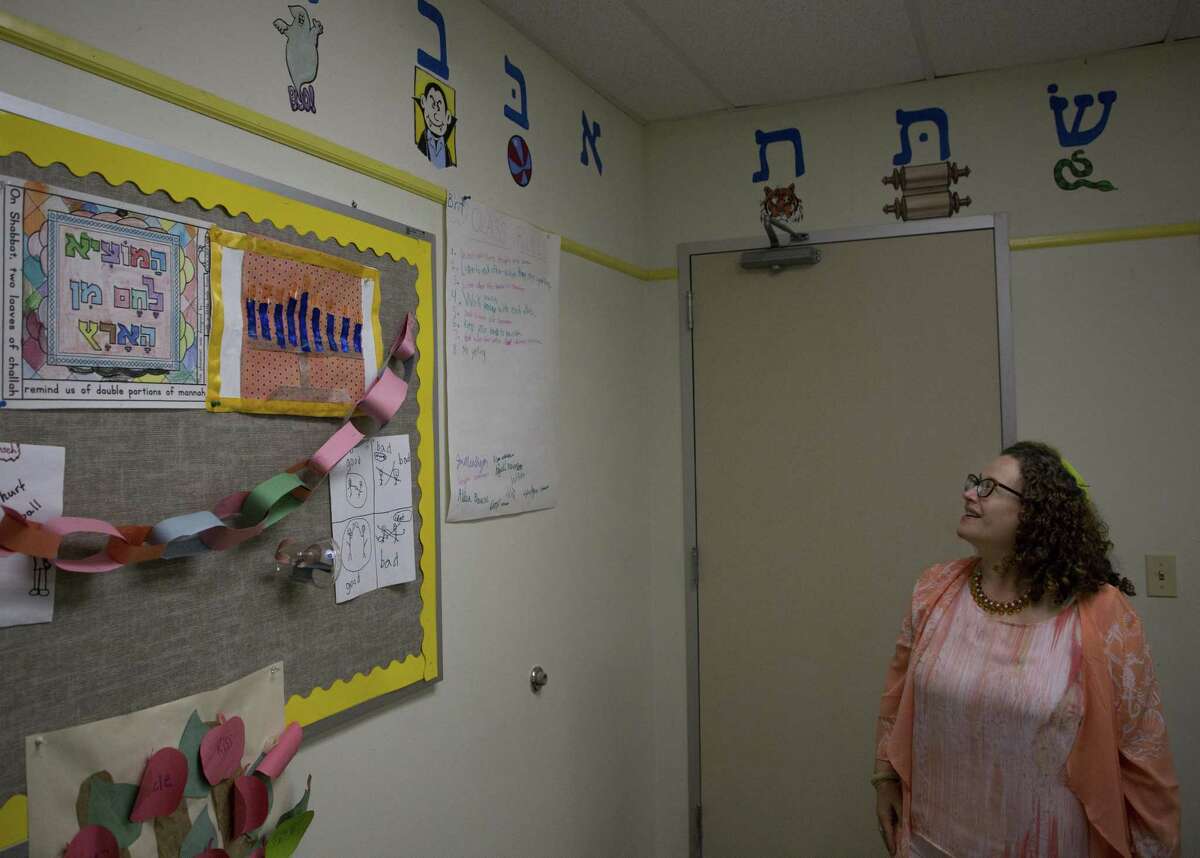 Rabbi Deborah Schloss looks up to the Hebrew alphabet that adorns the walls of the children's room at Temple Beth Tikvah Friday, Aug. 17, 2018, in Houston.