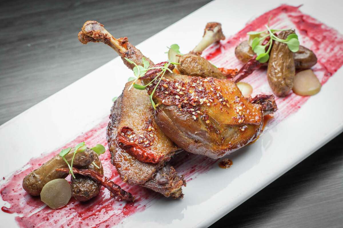 Crispy roasted duck legs with plum demi, pickled plum, chili oil and confit potatoes at Kitchen 713