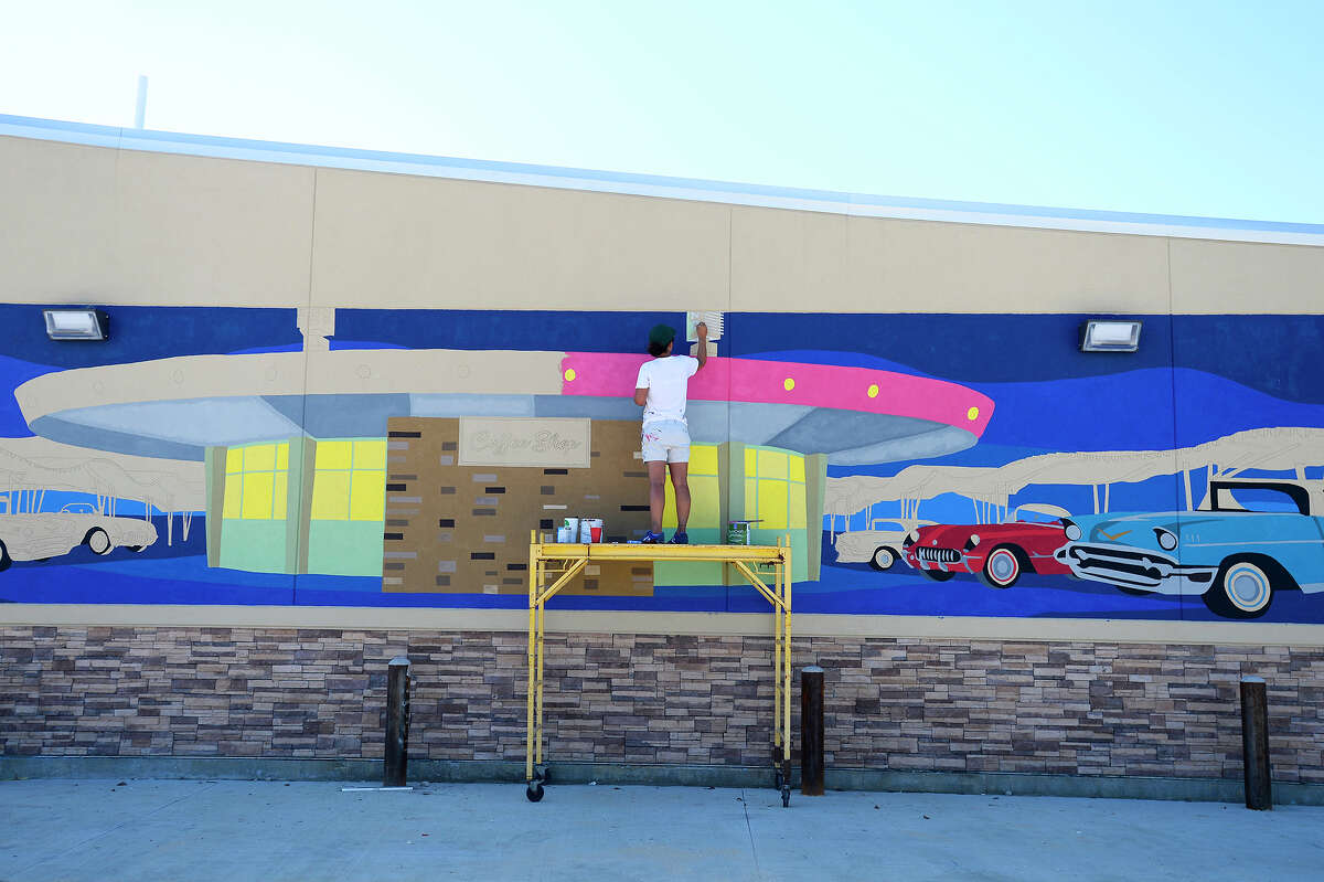 Kimberly Brown works on her mural of the iconic Pig Stand on the side of the gas station being built where the diner once stood. The mural is part of the Beaumont Convention and Visitors Bureau's downtown mural project to beautify the downtown area. Photo taken Monday 9/24/18 Ryan Pelham/The Enterprise