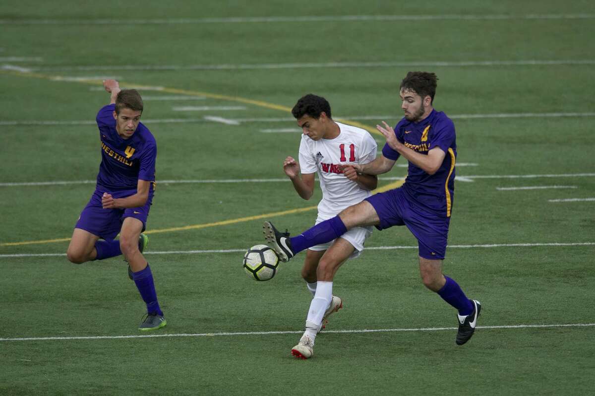 Westhill High School's Eoin Keogh stretches and takes control of the ball from Fairfield Warde junior Daniel Villalba during a varsity boys soccer game at Westhill in Stamford, Conn. on Monday, Sept. 24, 2018. Fairfield Warde defeated Westhill 3-2.