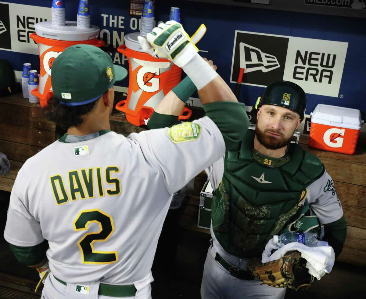Oakland's Khris Davis (2) and Jonathan Lucroy get pumped up just before the game against the Mariners; and as Tampa Bay trails toward the end of their game with the Yankees, clinching a wildcard spot for the A's, Monday, Sept. 24, 2018, at Safeco Field in Seattle. 207844