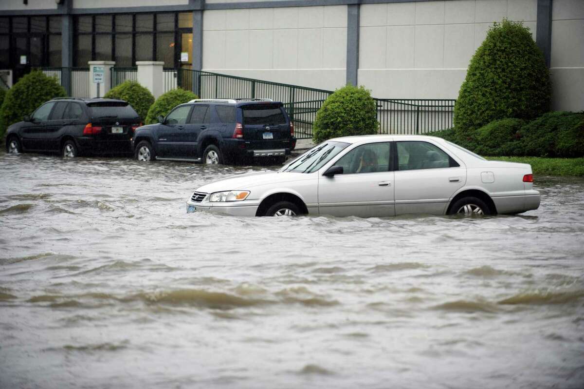 A car sits after being abandoned due to rising flood waters at the intersection of Jefferson Ave. and Harborview Ave. in south Stamford, Conn. on Tuesday, Sept. 25, 2018.