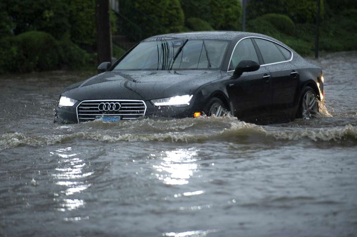 Cars slowly move through the flooded intersection of Jefferson Ave. and Harborview Ave. in south Stamford, Conn. on Tuesday, Sept. 25, 2018.