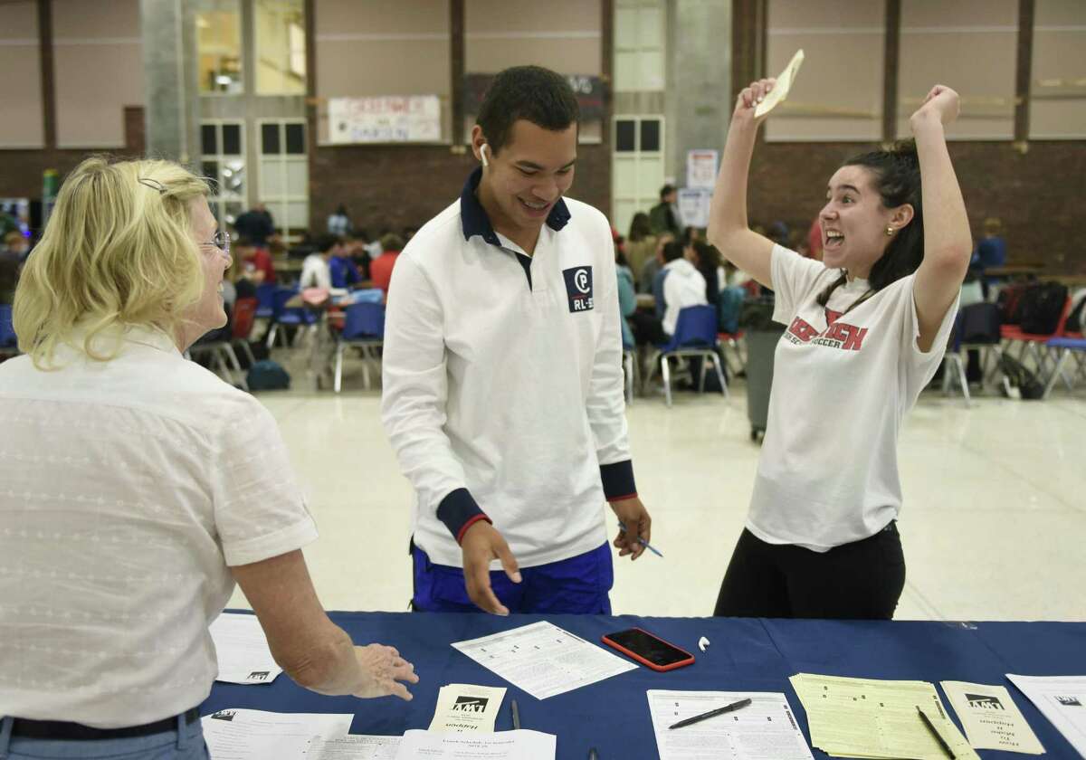 GHS senior Stevie Braverman celebrates after her friend Zahir Maheia, also a senior, signed up to vote with help from League of Women Voters of Greenwich voter service committee member Barbara Kavanagh at the LWV voting sign-up station at Greenwich High School in Greenwich, Conn. Tuesday, Sept. 25, 2018. The LWV set up a stand in the student center during the lunch periods in an nonpartisan effort to register eligible students to vote in the upcoming election.