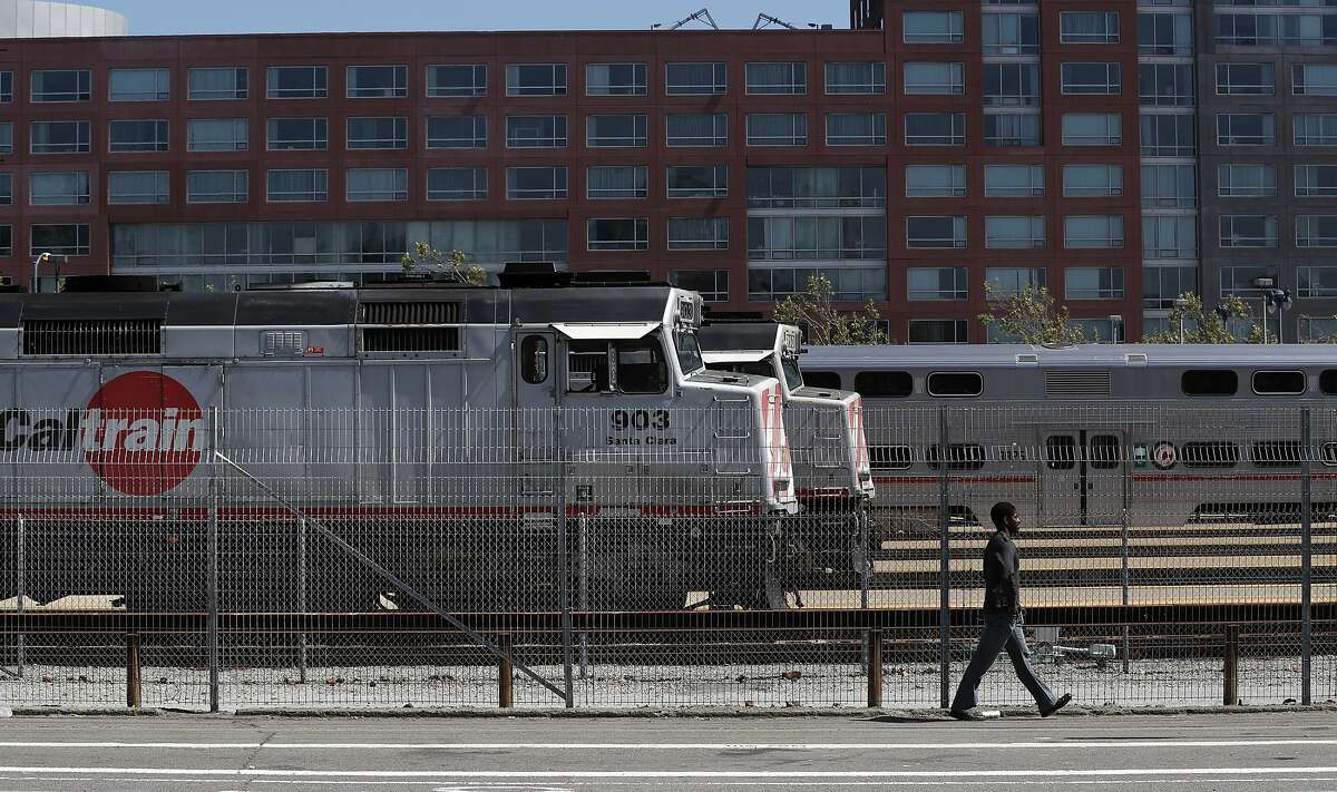 A man walks by stopped trains at the Caltrain rail station in San Francisco, Calif., on Sunday, April 22, 2018. A new report for a planned rail extension into downtown would now eliminate the need to demolish the I-280 extension, as previously proposed.