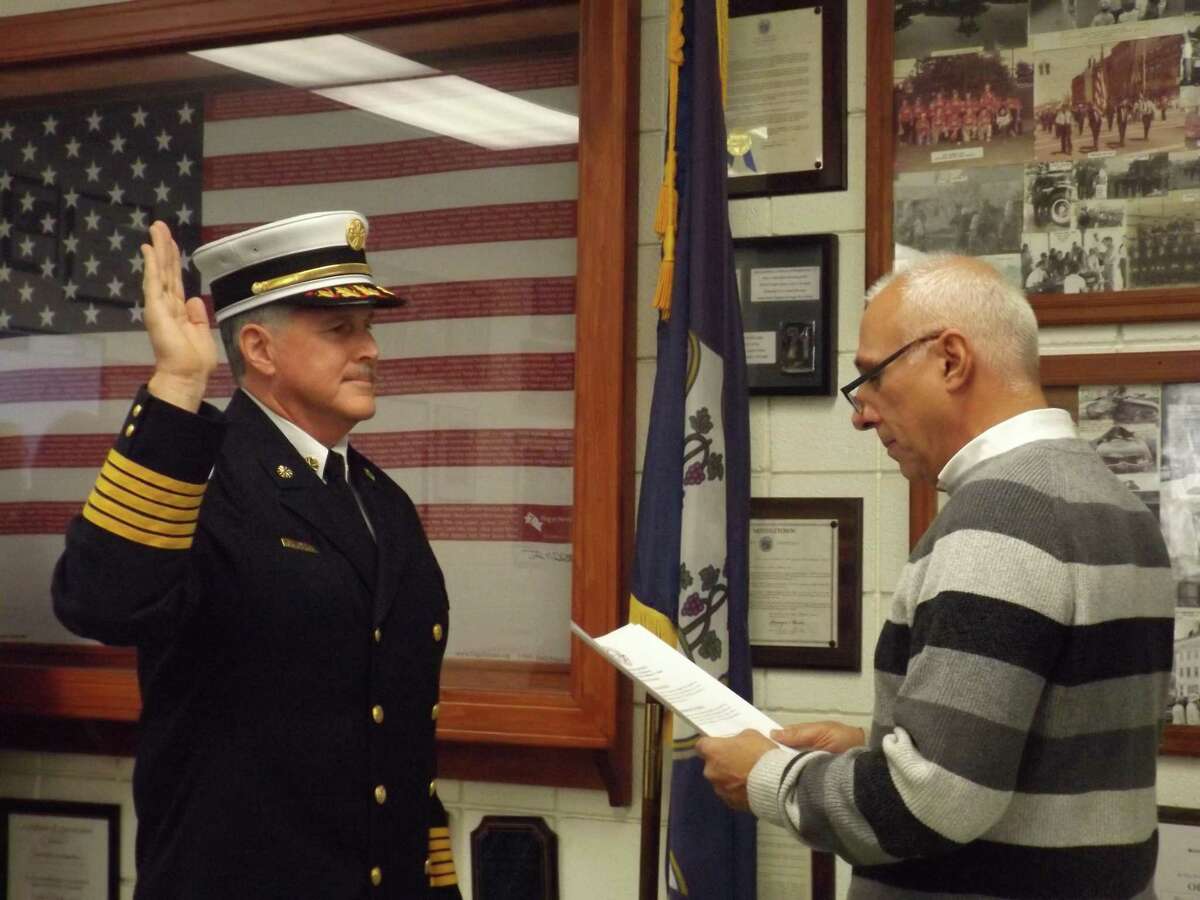 Former South Fire District Commission chairman David Gallitto, right, administers the oath of office to Chief Michael Howley in Middletown.
