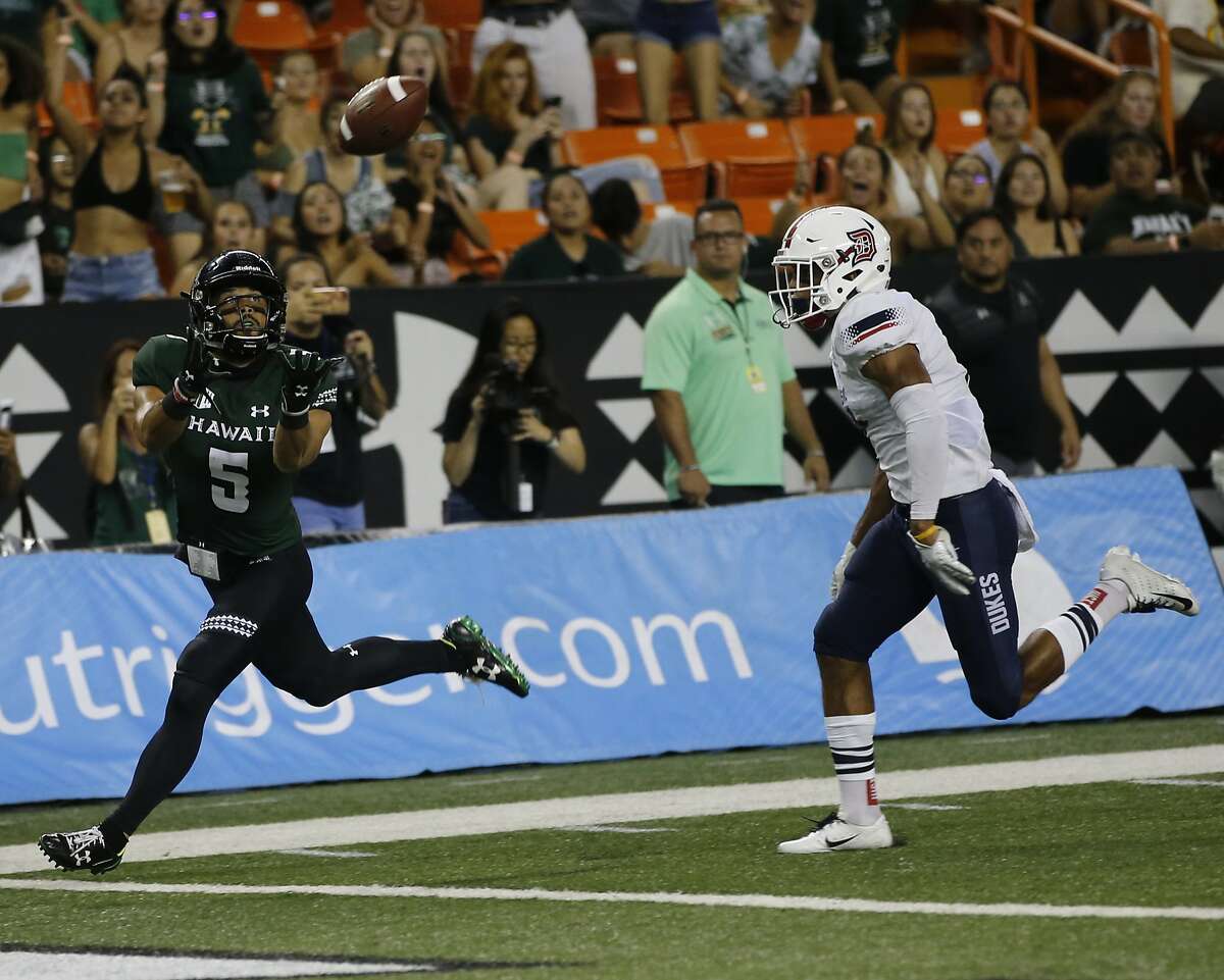 Hawaii wide receiver John Ursua (5) pulls in a touchdown pass in the end zone while being guarded by Duquesne defensive back Leandro Debrito (7) during the first half of an NCAA college football game Saturday, Sept. 22, 2018, in Honolulu. (AP Photo/Marco Garcia)