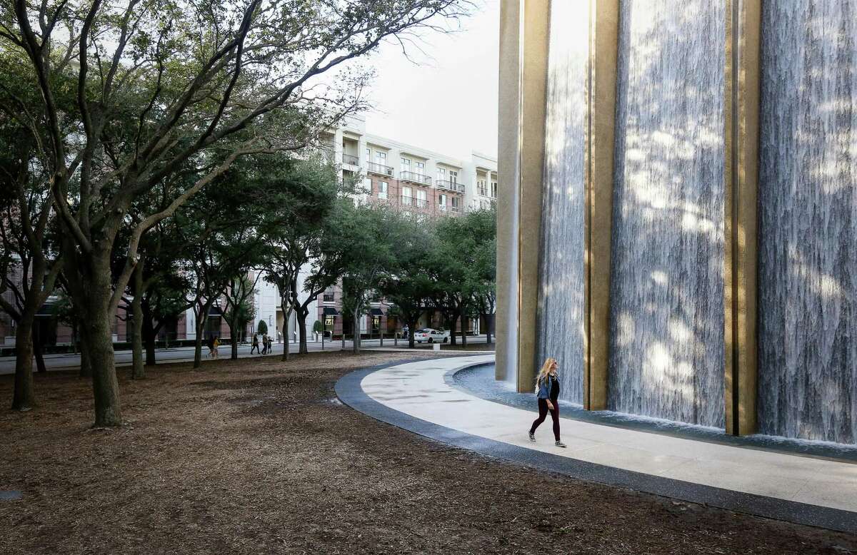 A woman walks through the Gerald D. Hines Waterwall Park, with the WaterWall Place apartments seen in the background, Tuesday, Jan. 3, 2017, in Houston. ( Jon Shapley / Houston Chronicle )