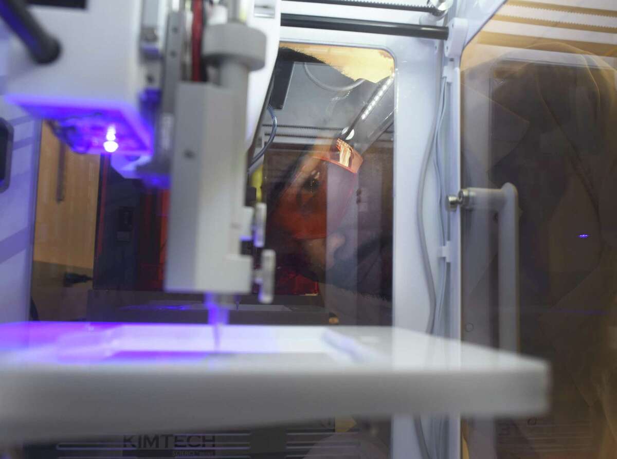 Joshua Gale looks over a 3D printer to be used to make a biodegradable polymer implant. It would contain cancer medication and would be inserted directly into a tumor to destroy it.