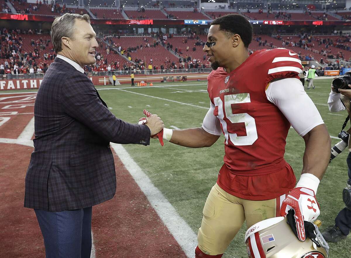 San Francisco 49ers general manager John Lynch, left, greets safety Eric Reid (35) after the 49ers beat the Jacksonville Jaguars in an NFL football game in Santa Clara, Calif., Sunday, Dec. 24, 2017. (AP Photo/Marcio Jose Sanchez)