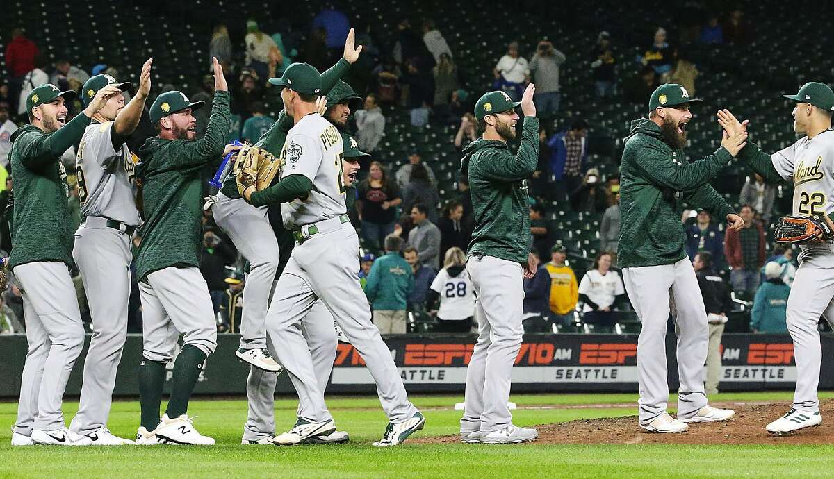 Oakland celebrates after defeating the Mariners, with the A's already clinching the wildcard earlier, Monday, Sept. 24, 2018, at Safeco Field in Seattle. The A's won, 7-3. (Ken Lambert/The Seattle Times/TNS)