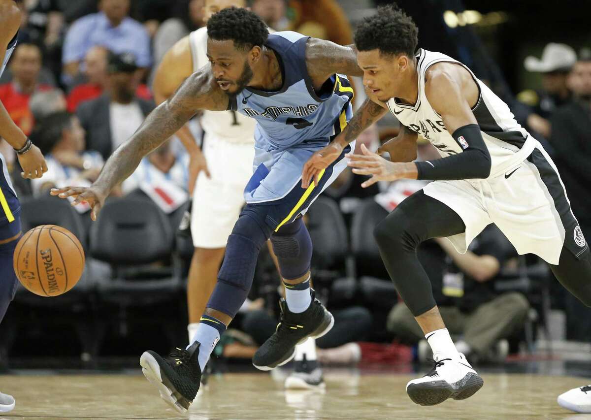 Memphis Grizzlies forward JaMychal Green (0) and San Antonio Spurs guard Dejounte Murray (5) chase after a loose ball during second half action Monday March 5, 2018 at the AT&T Center.