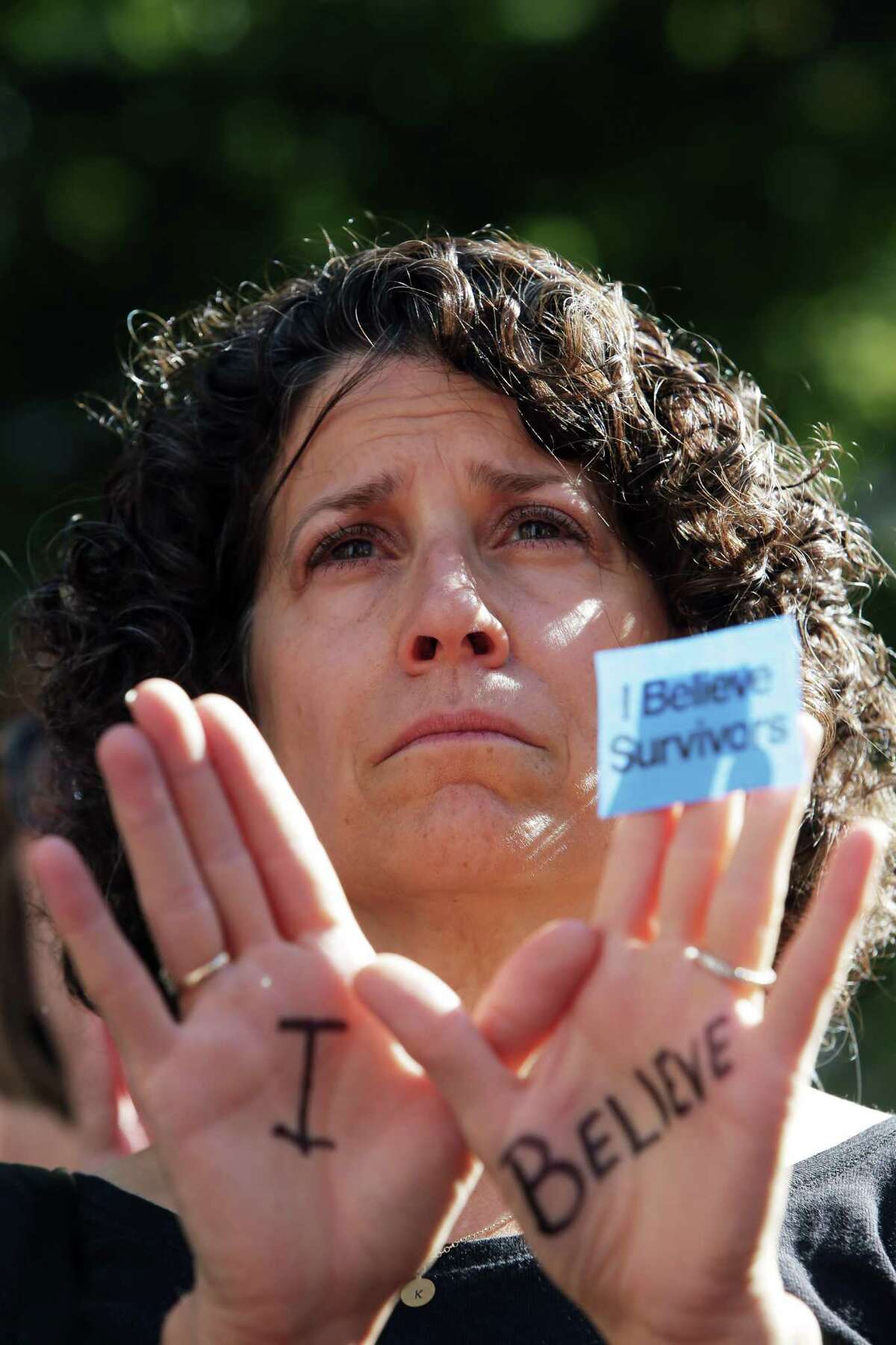 Karen Baer raises her hands with the words "I Believe" written on them as several dozen people gathered at Westlake Park at noon last week to show their support for Dr. Christine Blasey Ford as she testified in a Senate hearing about her sexual assault allegations against Supreme Court nominee Brett Kavanaugh, Sept. 27, 2018. Many of the people gathered had experienced sexual assault themselves and shared their stories. The event ended with a minute of silence in honor of victims of sexual violence.