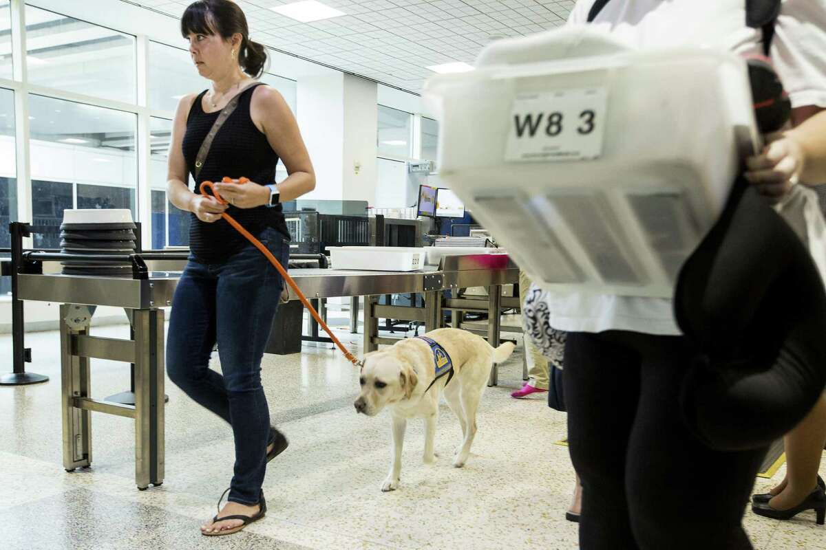 Robyn Schapiro and her service dog, Tyra, make their way through security in Terminal A at George Bush Intercontinental Aiport as they participate in a program that helps people with special needs train both their companion dogs and themselves about coming to and navigating around the airport on Thursday, Sept. 27, 2018, in Houston.