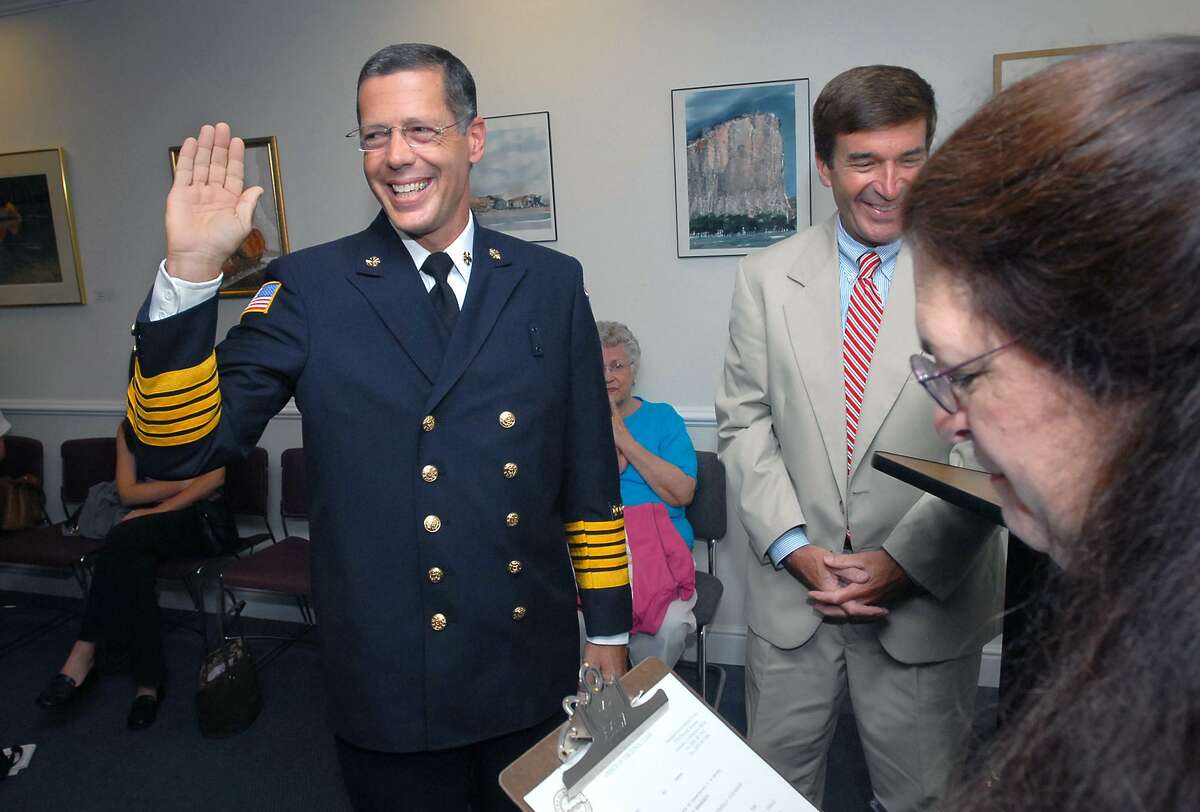 David Berardesca (left) is sworn in as the new Hamden Fire Chief by town clerk Vera Morrison (far right) at the Hamden Government Center on 8/15/2006. At right in back is Hamden Mayor Craig Henrici.