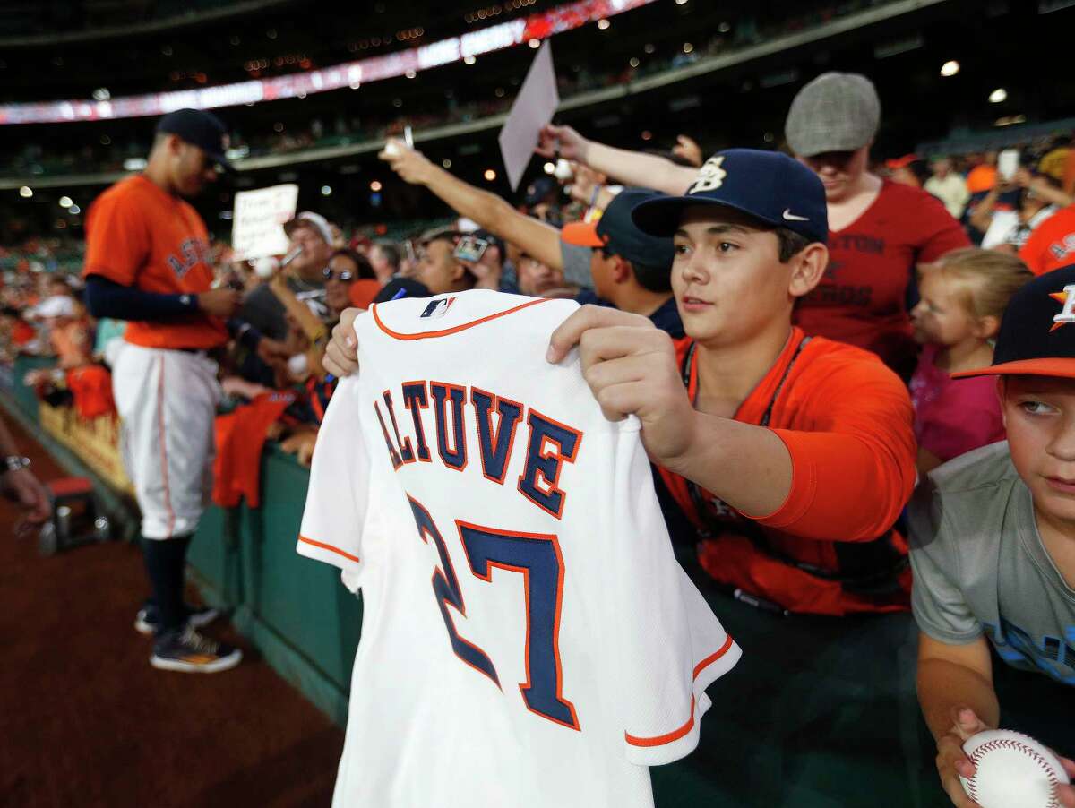 A fan waits for Houston Astros second baseman Jose Altuve (27) to sign his jersey before the start of the first inning of an MLB baseball game at Minute Maid Park, Friday, July 1, 2016, in Houston.