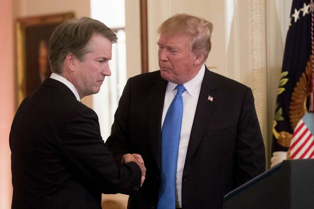 U.S. President Donald Trump, right, shakes hands with Brett Kavanaugh, appeals court judge, after being nominated as an associate justice of the U.S. Supreme Court by Trump on July 9. Kavanaugh’s treatment by the press and others strengthens the view of Trump’s base about a rigged game.
