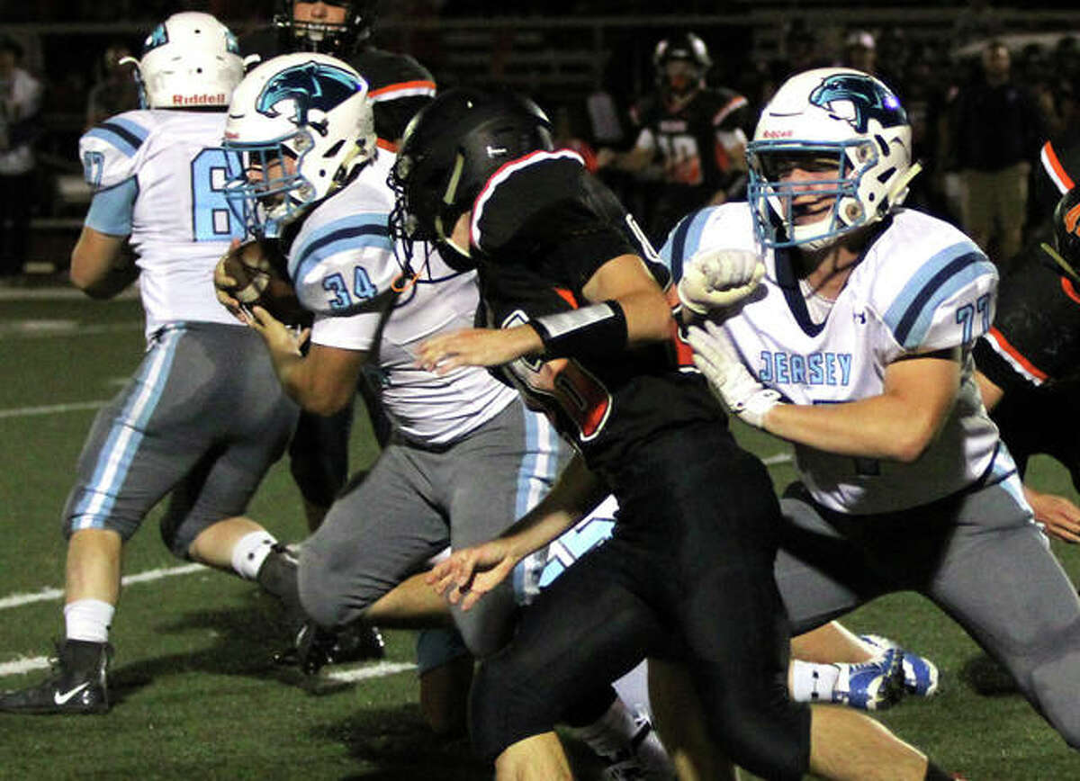 Jersey fullback Brian McDonald (34) runs through a hole off the block of Zac Mueller in Mississippi Valley Conference football action Friday night in Waterloo. McDonald rushed for 116 yards and two TDs in the Panthers’ 28-26 victory.