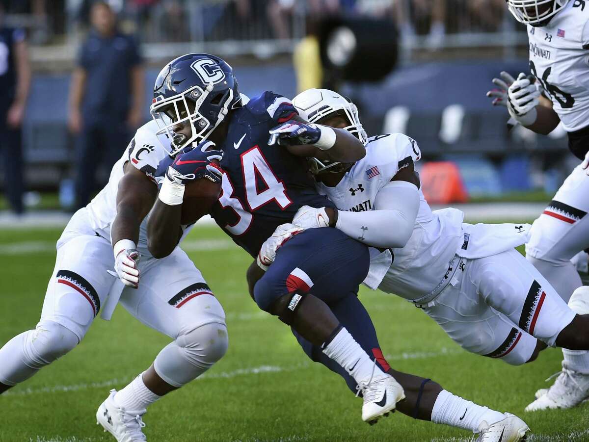UConn running back Kevin Mensah (34) is stopped during the first half against Cincinnati on Saturday.