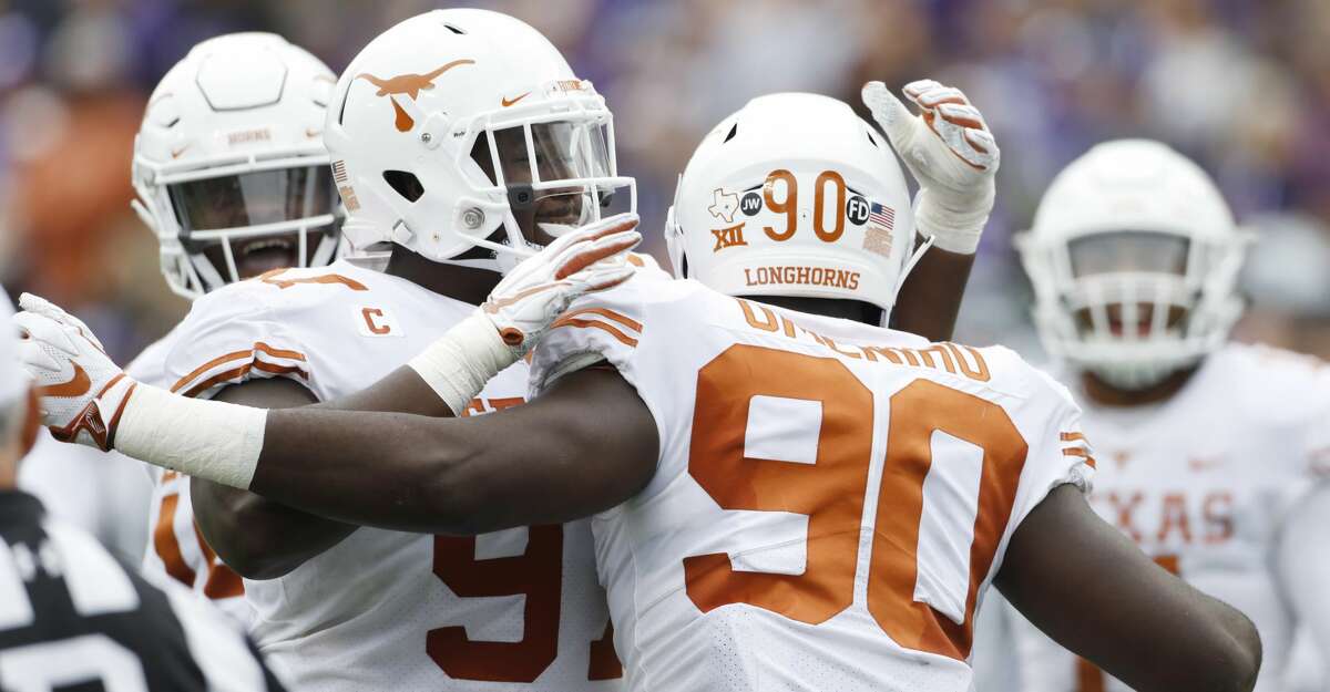 Texas defensive linemen Jamari Chisholm (91) and Charles Omenihu (90) celebrate after sacking Kansas State quarterback Alex Delton for a safety during the second quarter of a college football game in Manhattan, Kan., Saturday, Sept. 29, 2018. (AP Photo/Colin E. Braley)