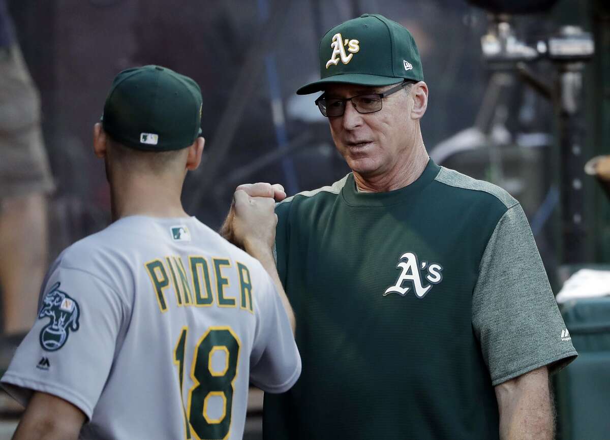 Oakland Athletics manager Bob Melvin, right, gives a fist-bump to Chad Pinder before the team's baseball game against the Los Angeles Angels on Saturday, Sept. 29, 2018, in Anaheim, Calif. (AP Photo/Marcio Jose Sanchez)
