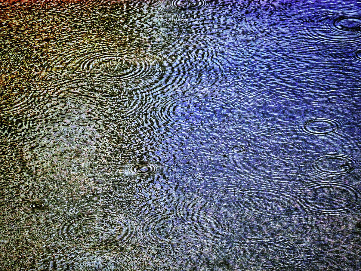 Patterns are formed as raindrops land on a puddle during last week's showers.