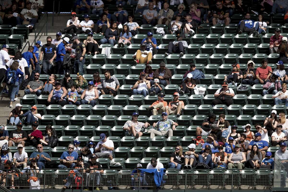 Fans watch the game between the San Francisco Giants and the Los Angeles Dodgers in the fourth inning of a baseball game in San Francisco, Sunday, Sept. 30, 2018. (AP Photo/John Hefti)